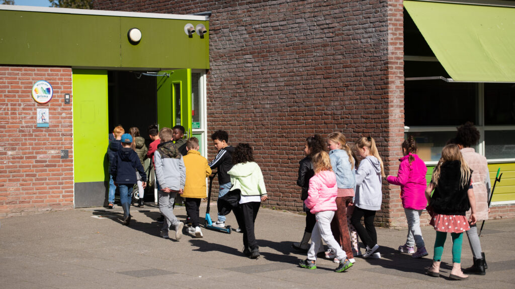 leerlingen lopen een school in